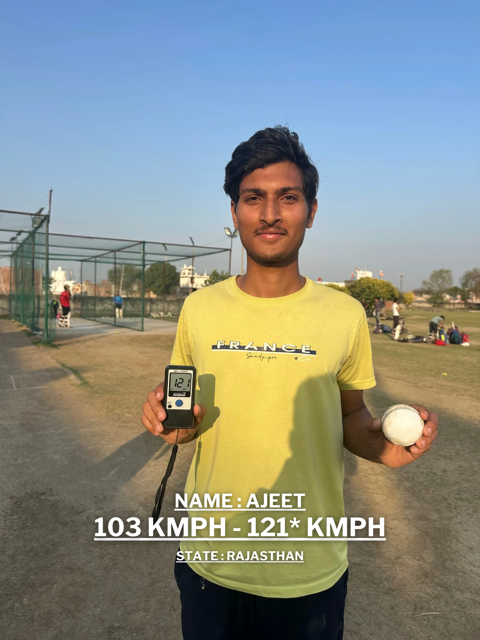 A young man is holding a cricket ball and a digital speedometer displaying his improved bowling speed at the Pathak100mph Cricket Academy.